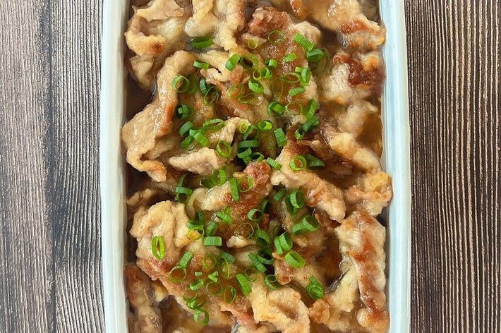 豚こま切れ肉の梅だれ和えがホーローに入っている。小ネギが散らされている。