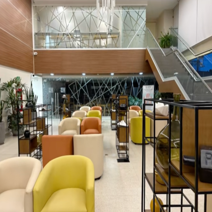 Modern lobby with mixed seating arrangements, decorative vases on metal shelves, abstract wall art, and plants, evoking a cozy and stylish atmosphere