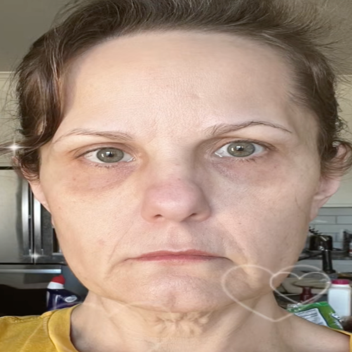 Person with a neutral expression facing the camera in a home setting