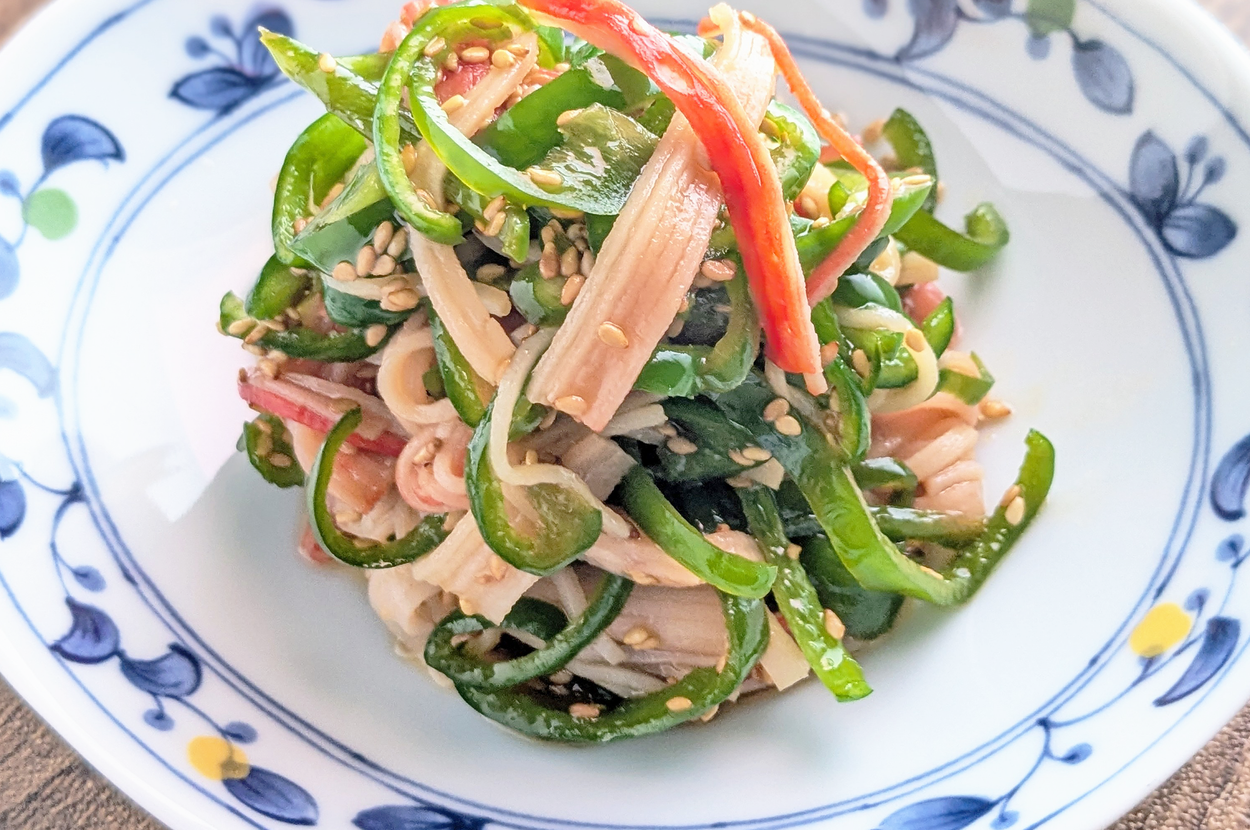 皿に盛られた美しく盛り付けられた野菜の和え物。ゴマが上に振りかけられている。