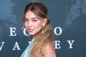Person in elegant off-shoulder gown poses confidently at a formal event