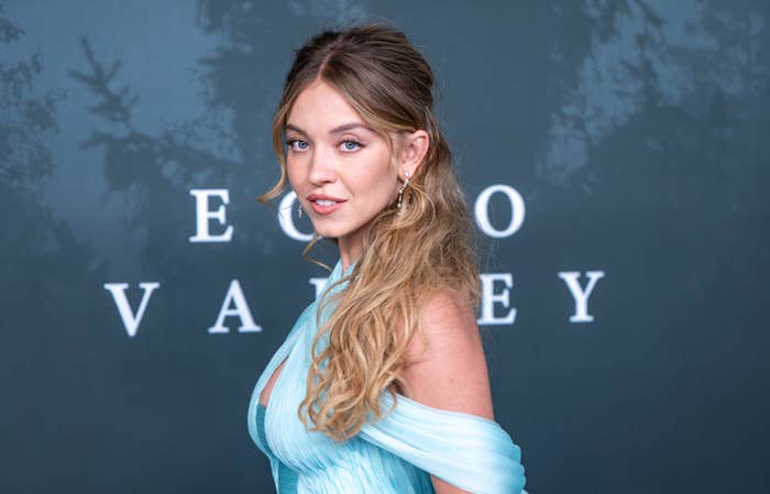 Person in elegant off-shoulder gown poses confidently at a formal event