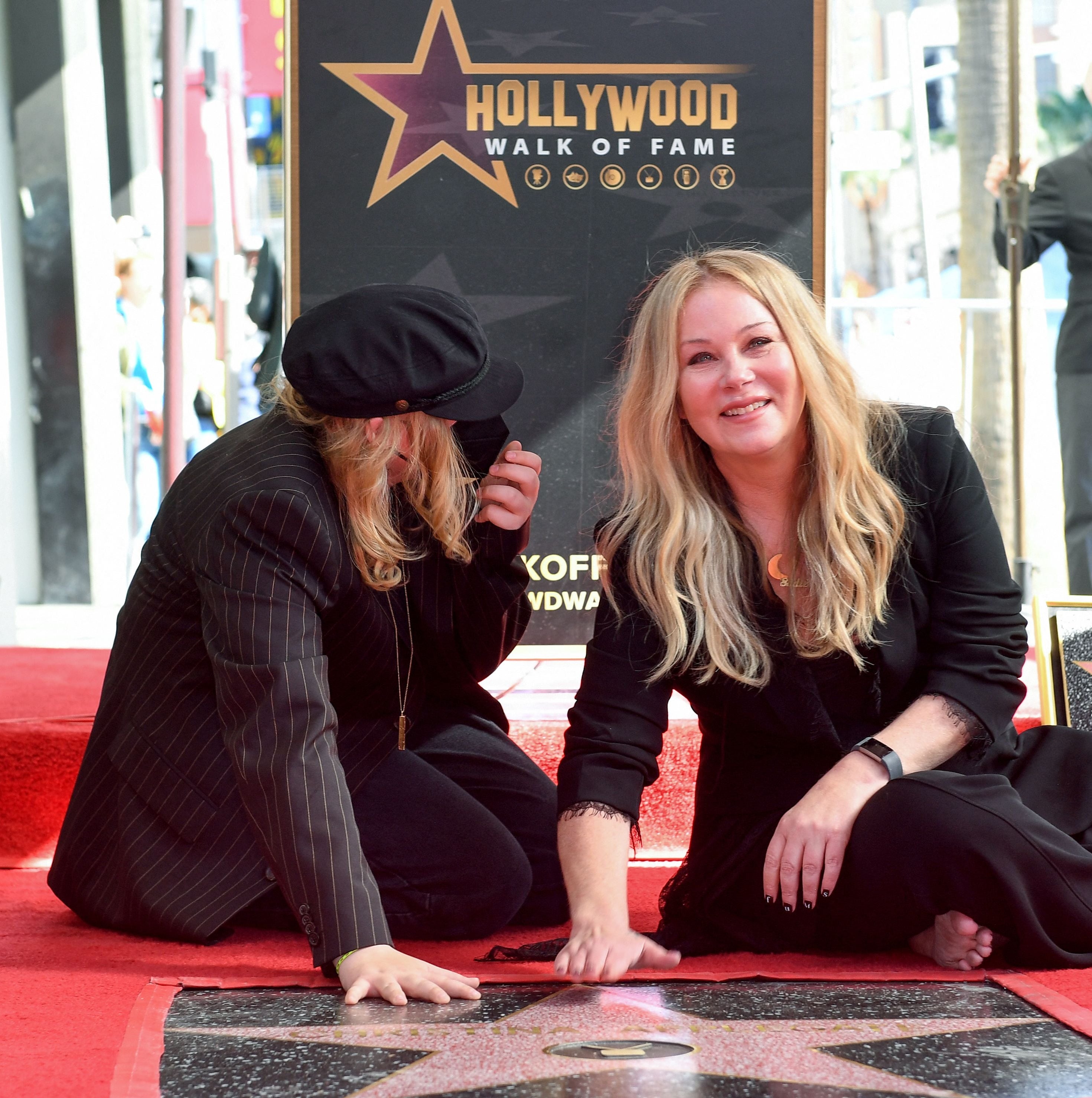 Christina Applegate and her daughter Sadie sitting on her Hollywood Walk of Fame star