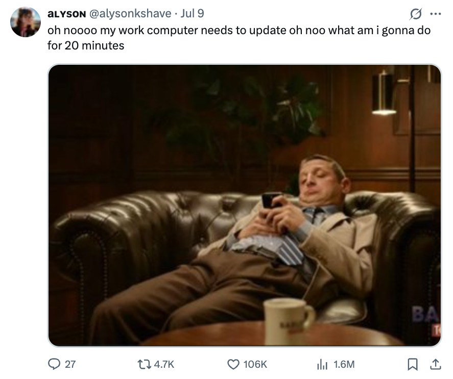 Person in a suit is lounging on a leather couch, looking at their phone