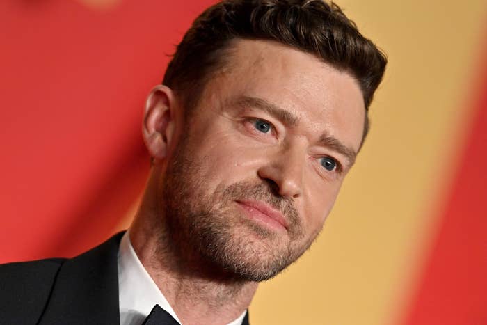 Justin Timberlake in a tuxedo poses on a red carpet