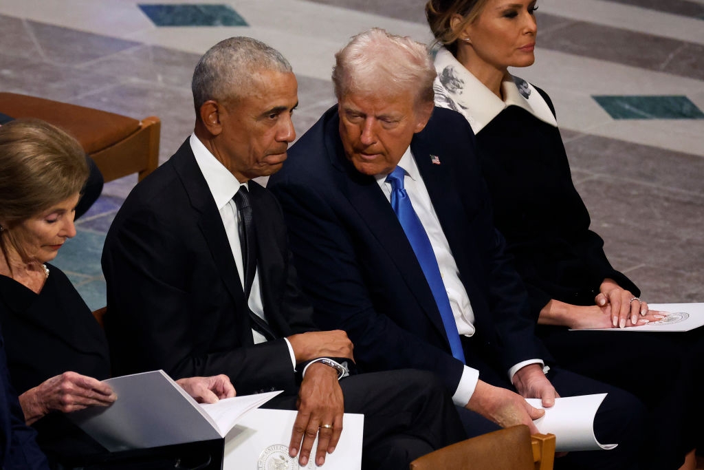 Former U.S. President Barack Obama and U.S. President-elect Donald Trump visit as former first ladies Laura Bush (L) and Melania Trump (R) look on during the state funeral for former U.S. President Jimmy Carter