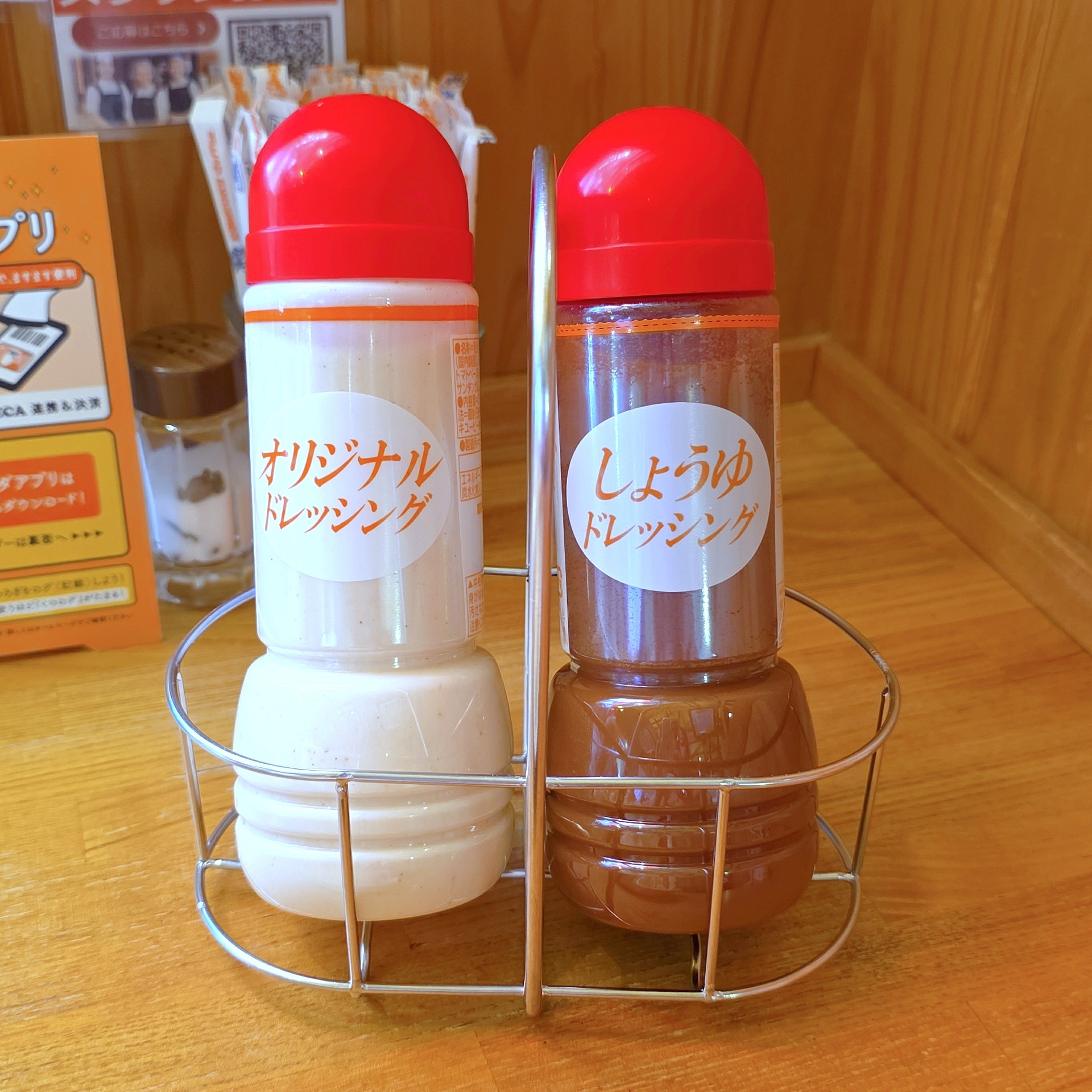 卓上に置かれたオリジナルとしょうゆドレッシングのボトルが2本、金属製のホルダーに入っています。