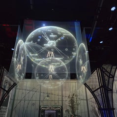 Proyección digital de esferas con patrones geométricos y simbología futurista en una exposición tecnológica