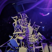 Varias sillas de diferentes estilos apiladas artísticamente en un entorno moderno