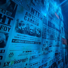 Periódico con titulares sobre criminales buscados y advertencias. Destaca el nombre "Amycus Carrow" y se exhorta a tener precaución