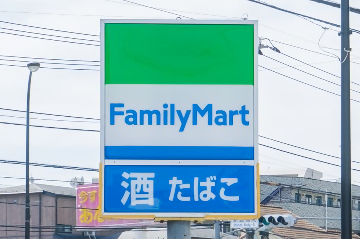 ファミリーマートの看板があり、「酒 たばこ」と書かれています。電線や建物が背景に見えます。