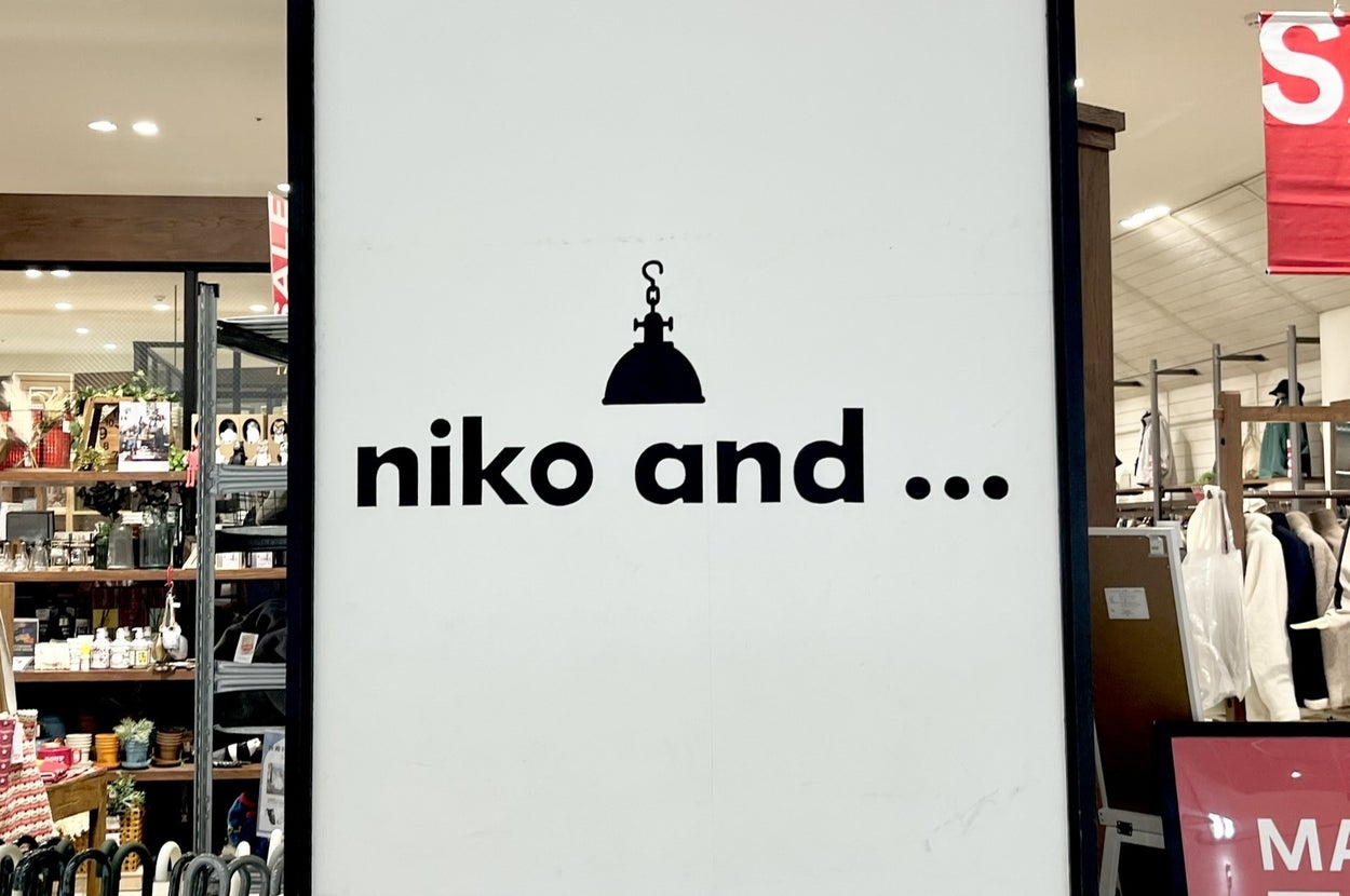 "Niko and ..." store sign in a shopping area, with shelves displaying various products in the background