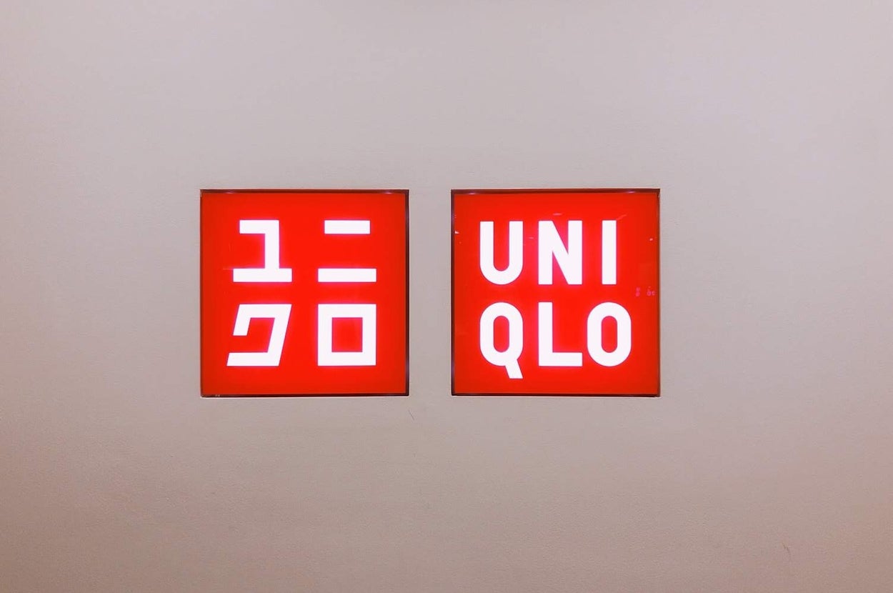 Two red signs with white text. The left sign has Japanese characters, and the right sign reads "UNIQLO."