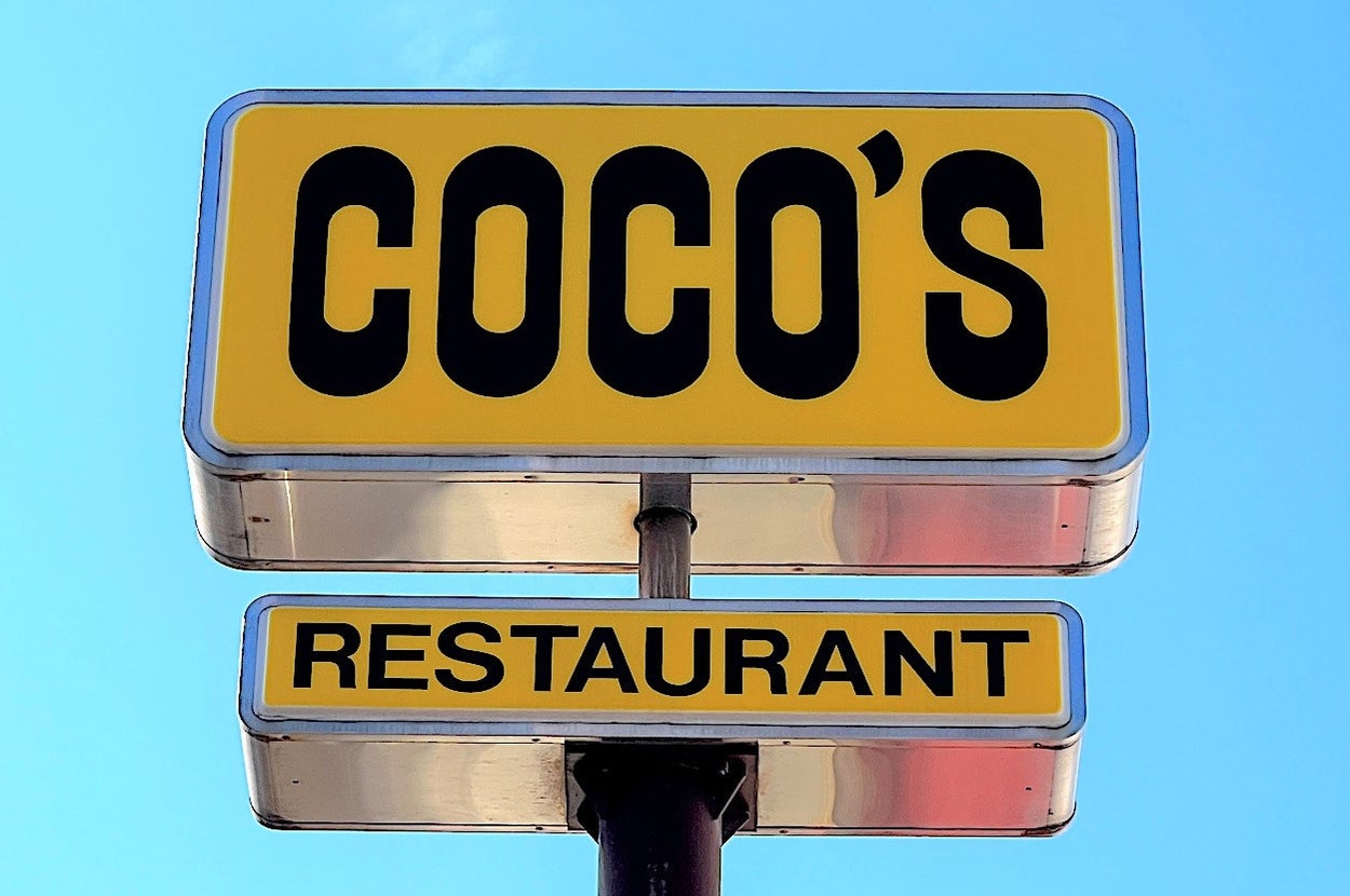 Sign for Coco's Restaurant against a clear sky