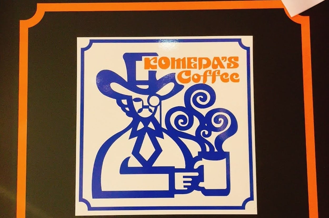 帽子と眼鏡の人物がコーヒーカップを持つデザイン。「COMEPA'S Coffee」の文字あり。