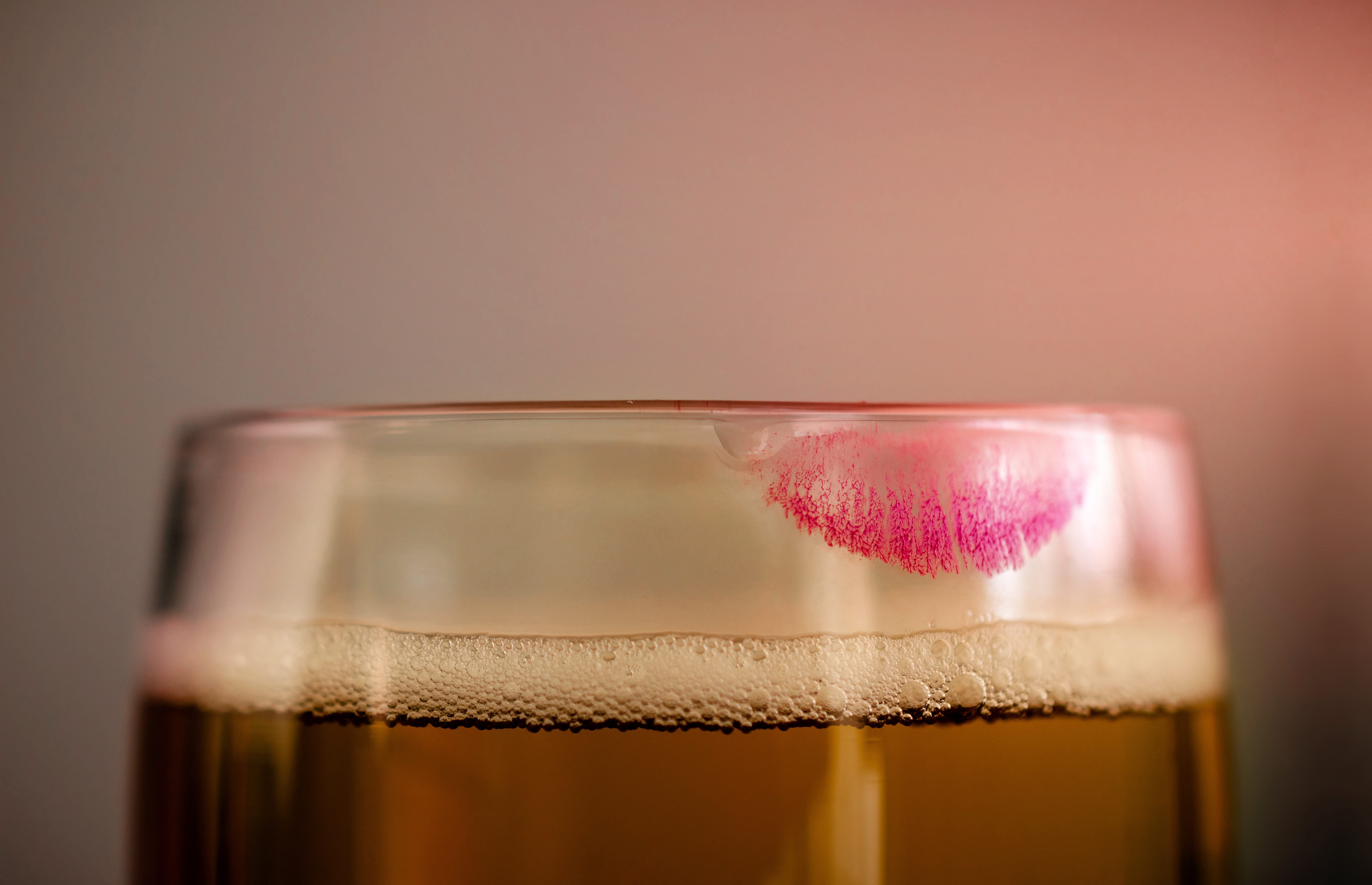 Close-up of a beer glass with a lipstick mark on the rim