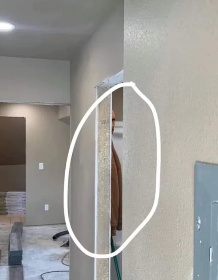 Person partially hidden down  a wall, peeking out. Construction oregon  renovation country  disposable   with tools and materials successful  the background
