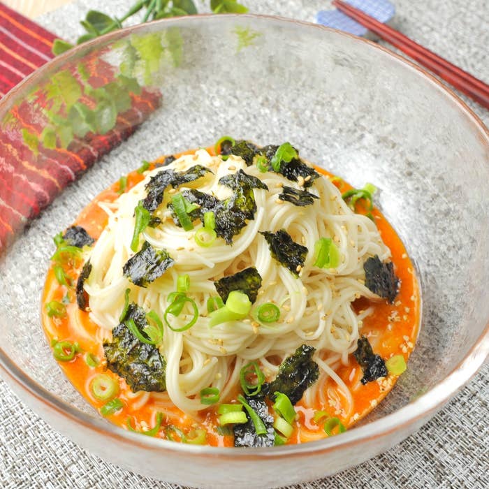 ガラスの器に盛られた冷麺、海苔とネギがトッピングされています。