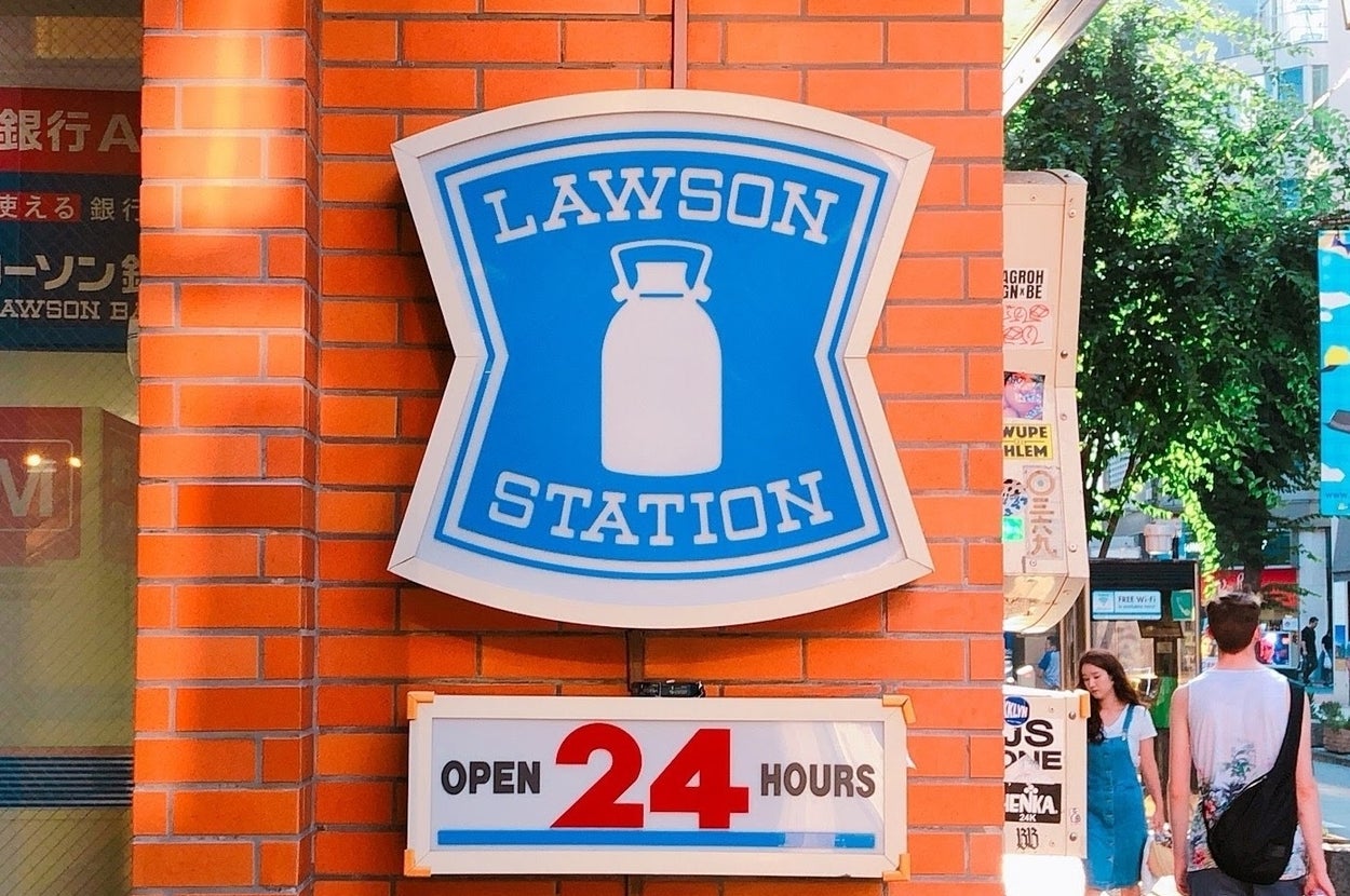 ローソンの24時間営業を示す看板。牛乳瓶のアイコンと「LAWSON STATION」の文字が特徴。