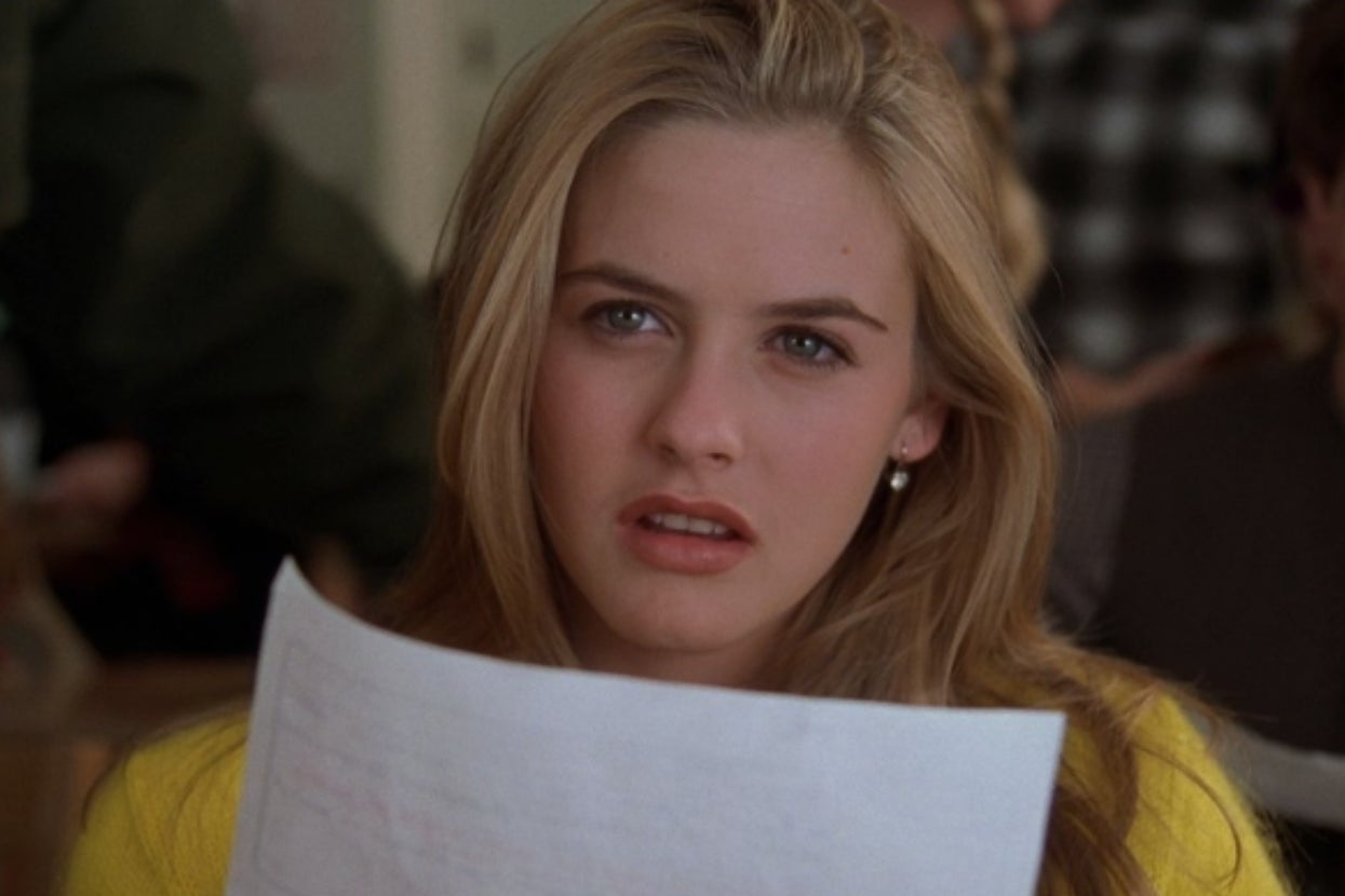 Person holding a piece of paper, looking confused, set in a classroom environment