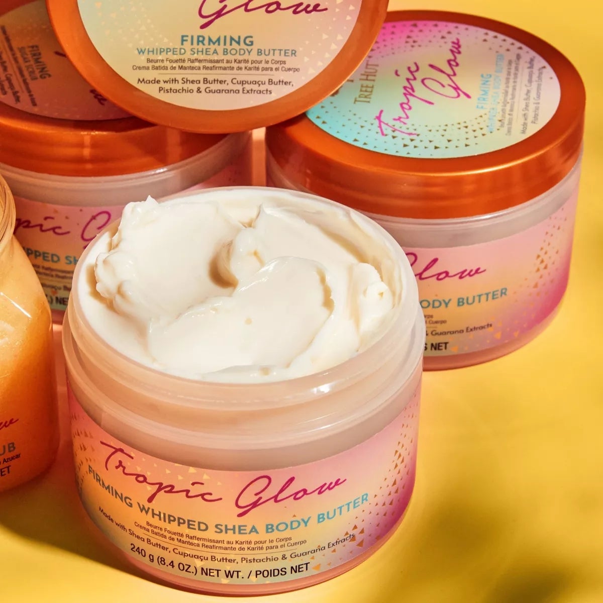 Stoples dari pohon panas tropic piring kocok shea body butter berkumpul bersama, dengan satu terbuka untuk menunjukkan krim tubuh