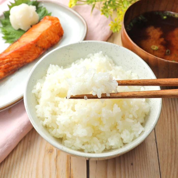 ご飯が入った茶碗、鮭の切り身、味噌汁が並ぶ和食の朝食。