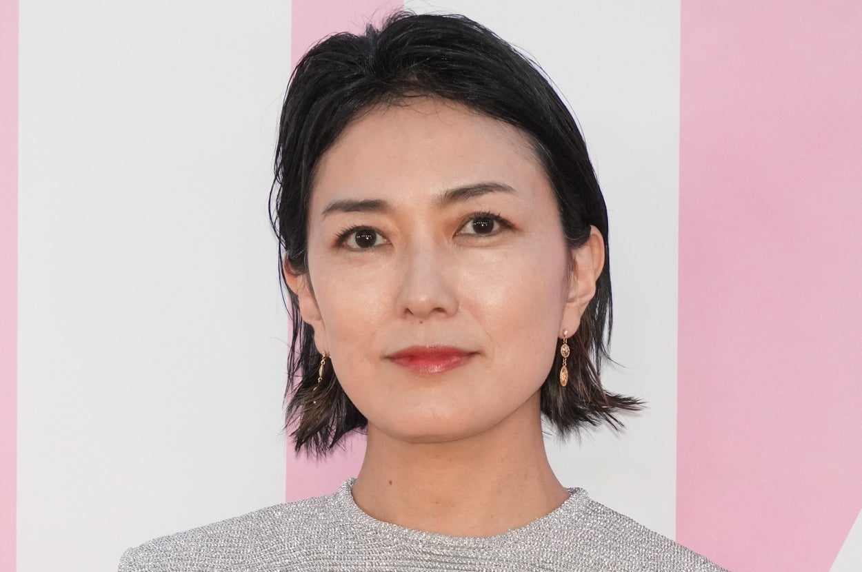 女性がシルバーのフリンジドレスを着てポーズをとっている。シンプルなイヤリングを着用。