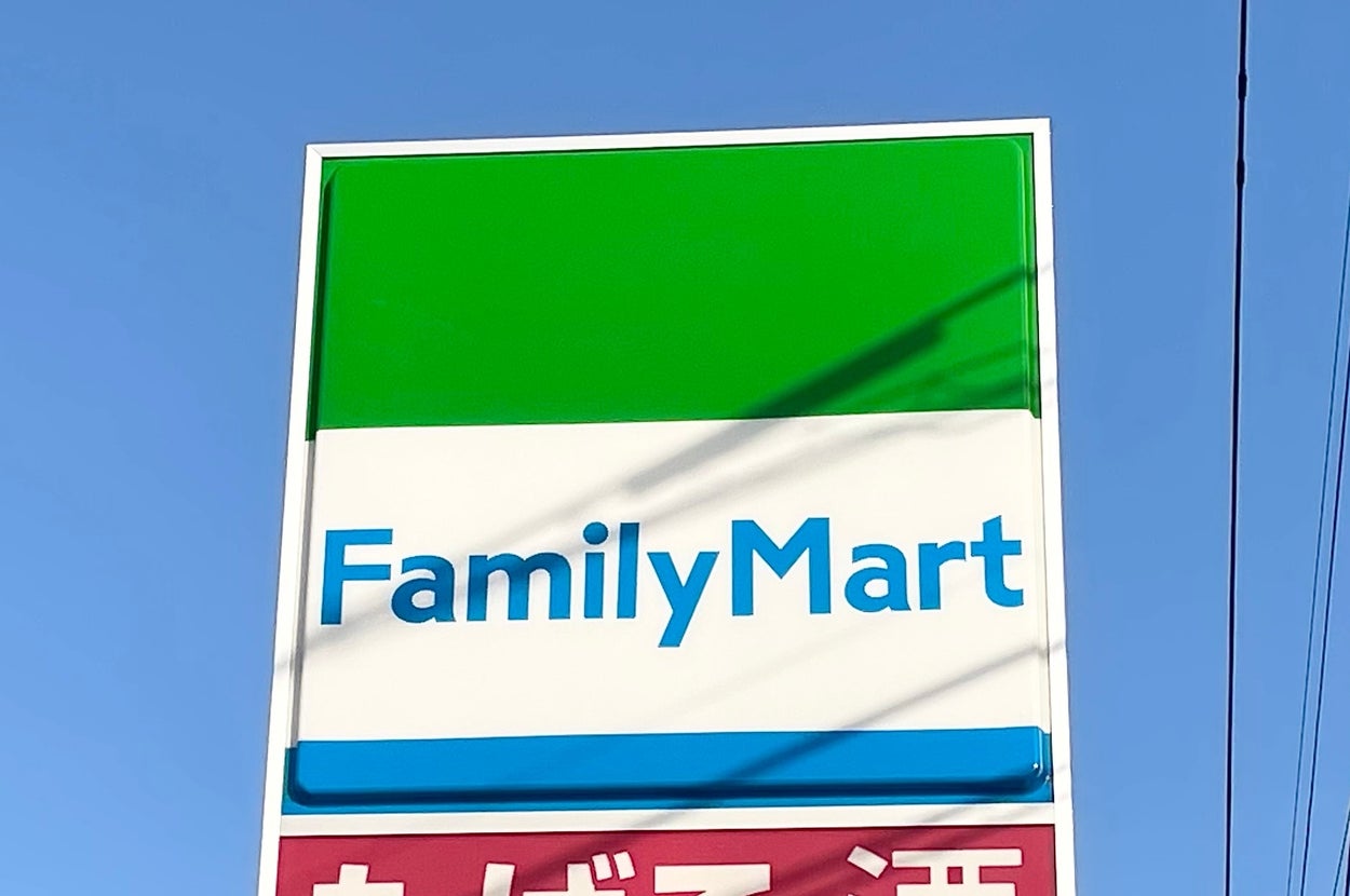 ファミリーマートの看板。たばこ・酒、ATMのアイコンが表示されている。電柱が背景に見える。