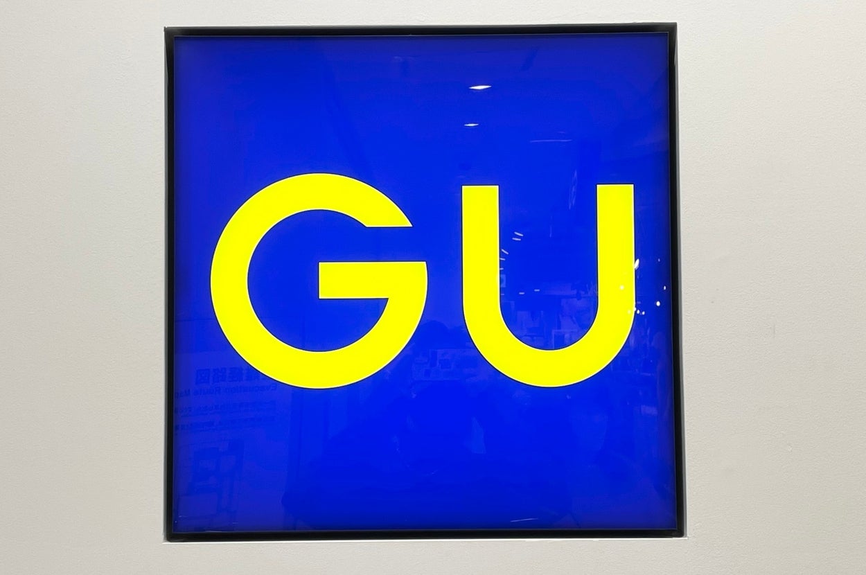 Square sign with bold "GU" letters
