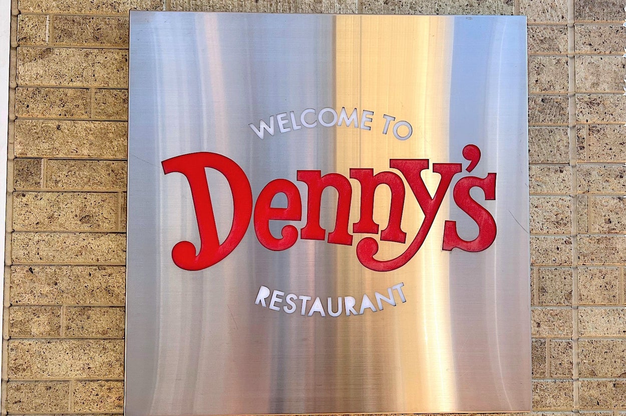 Sign on a brick wall welcoming customers to Denny's restaurant