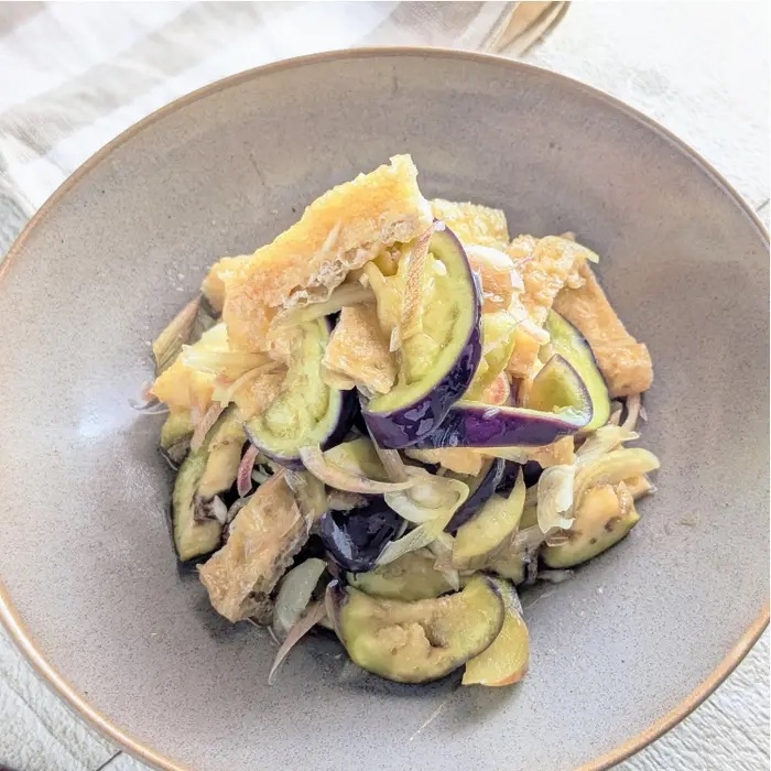 器に盛られた野菜と揚げ物の料理。ナスや玉ねぎが含まれている。