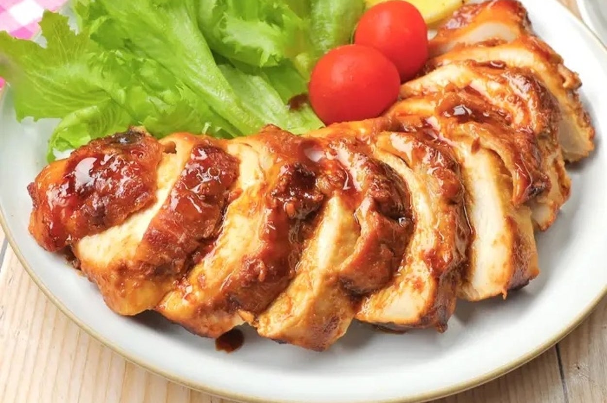 鶏肉の照り焼きがスライスされ、レタス、ミニトマト、レモンが添えられた皿。