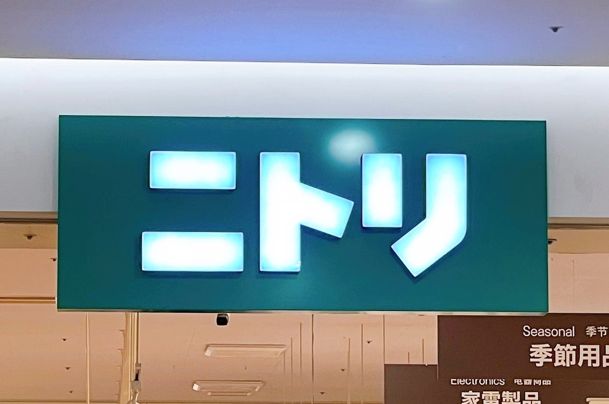 ニトリ店舗の看板が天井から吊り下げられています。周囲には「季節用品」や「家電製品」の案内があります。