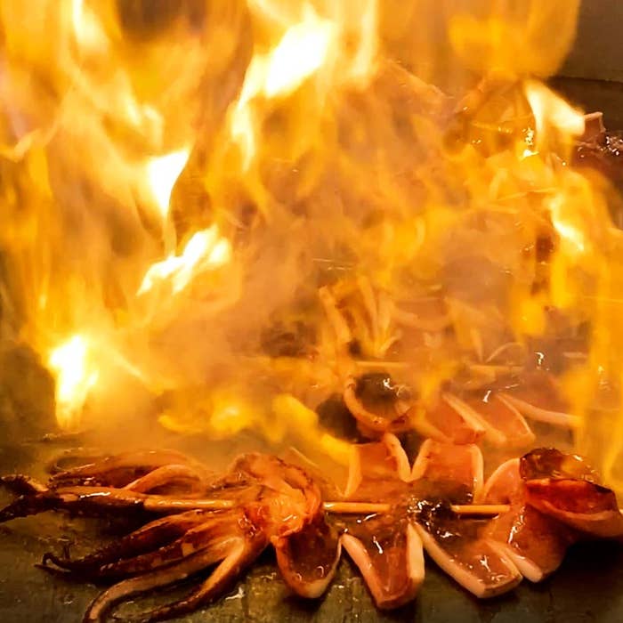 豪快に燃え上がる炎で焼き上げられたアメ横酒場「山賊海賊」のイカ焼き