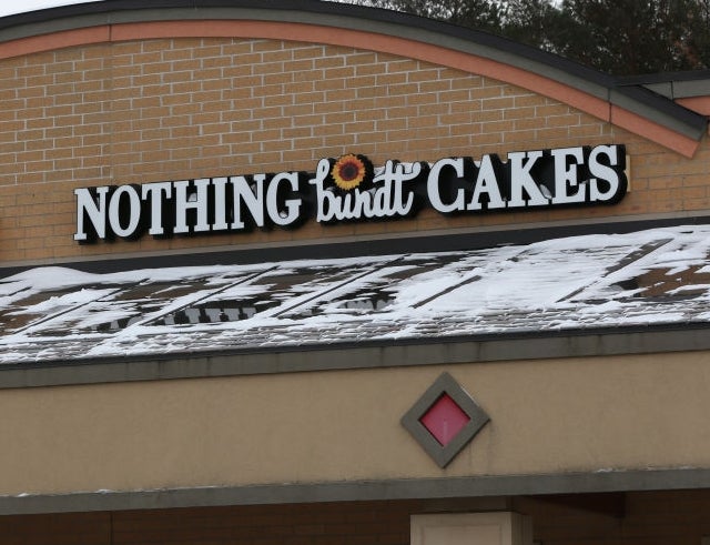 Storefront with WeightWatchers and Nothing Bundt Cakes signs. Snow is on the awning