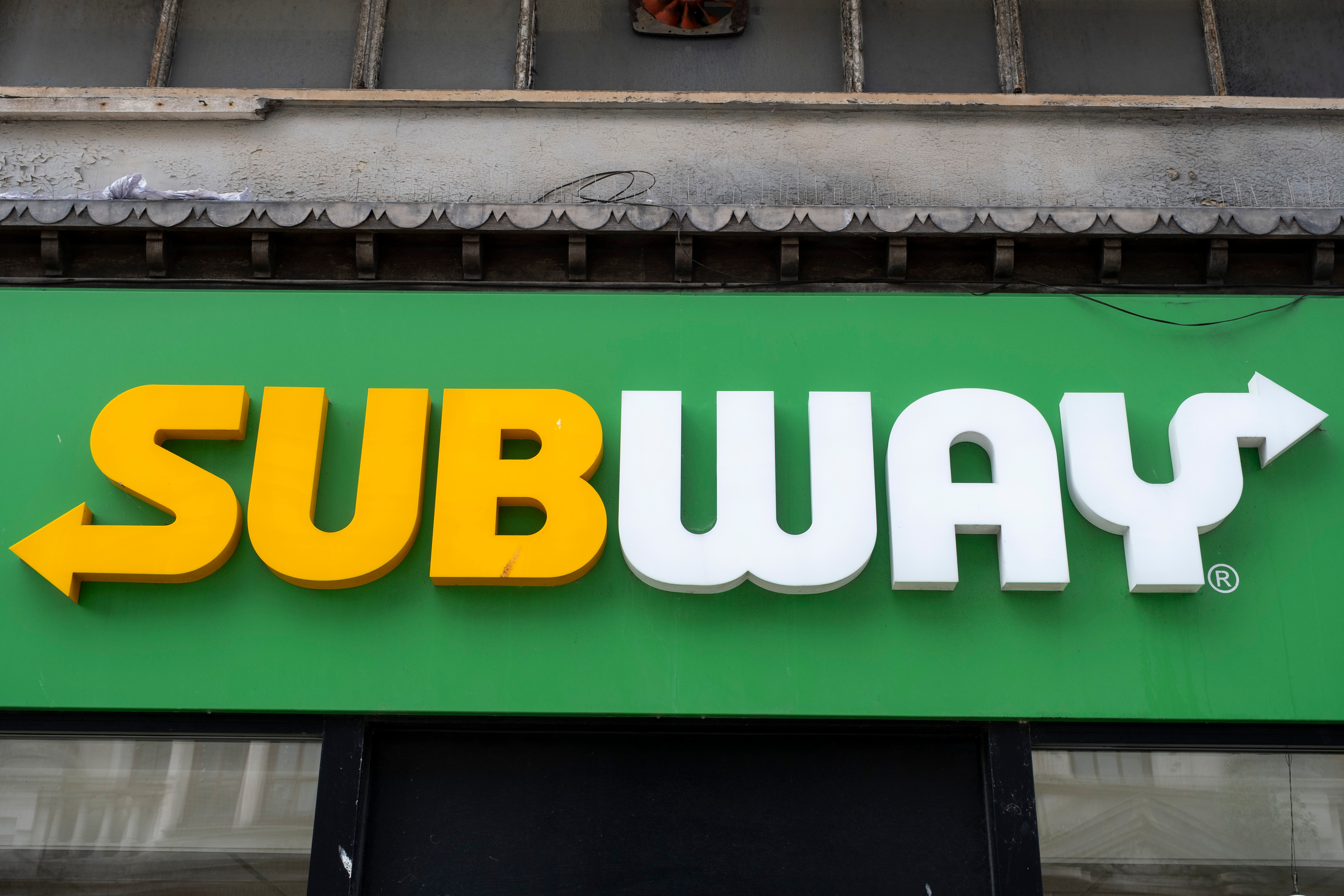 Subway restaurant sign with bold yellow and white lettering against a green background