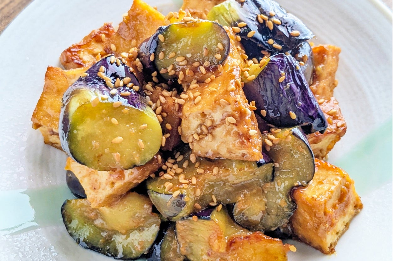 皿に盛られた焼きナスと豆腐の料理。ゴマがトッピングされている。