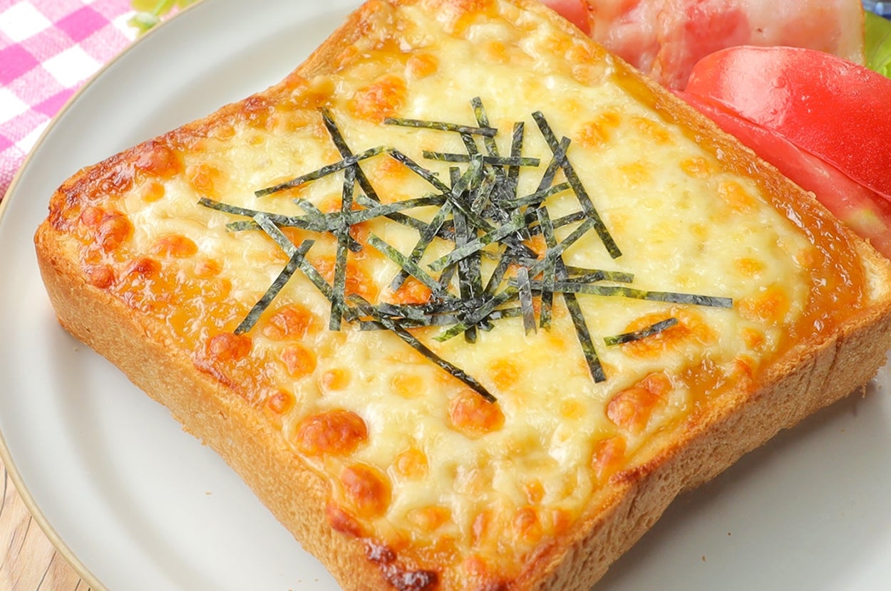 チーズトーストに海苔が乗り、野菜と冷たい飲み物が添えられている。バックグラウンドにピクニック用テーブルクロス。