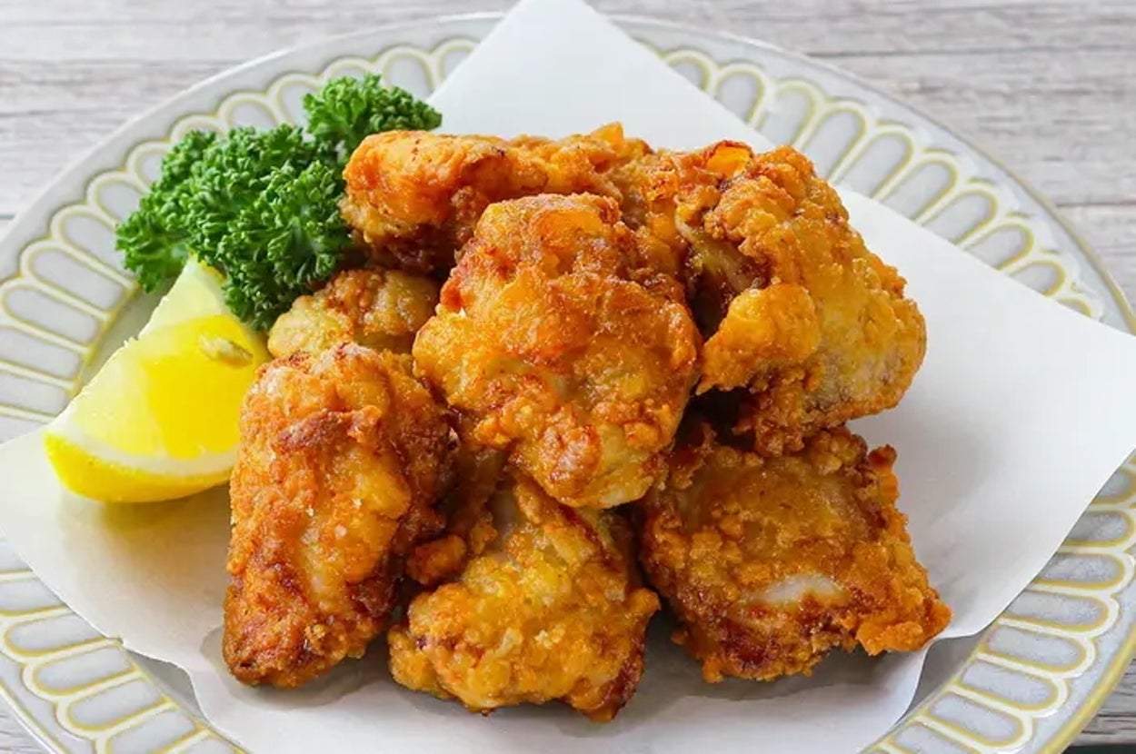 皿に盛られたカリカリに揚げられた唐揚げ、レモンとパセリが添えられています。