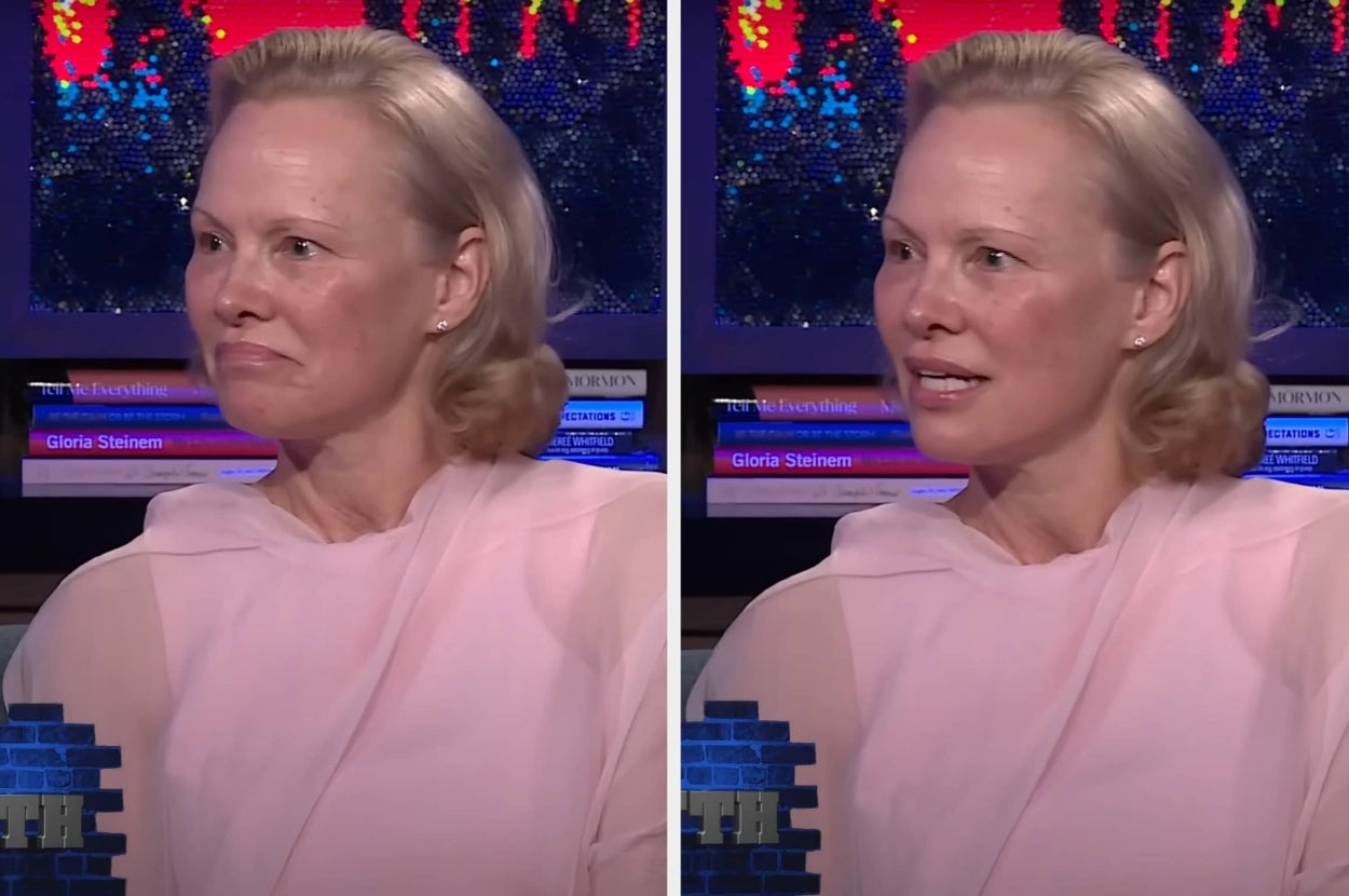 A woman with short blonde hair is seated, wearing a flowing, sheer outfit. She's in a casual conversation setting on a talk show