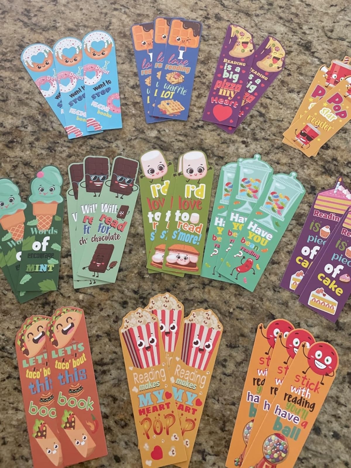 Assorted festive bookmarks with playful phrases about reading and snacks, featuring cartoon characters like tacos, popcorn, and popsicles