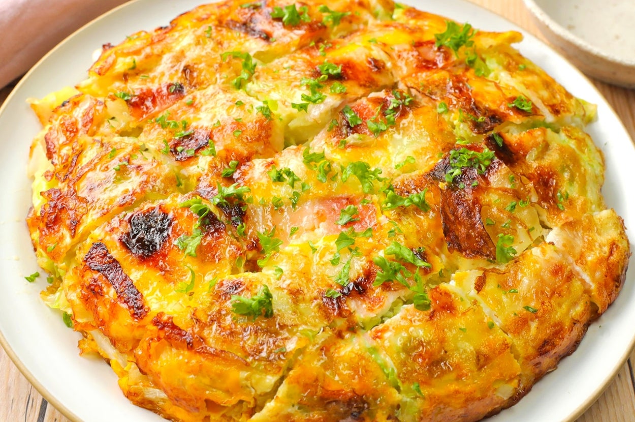 巨大なオムレツのように見える料理が皿に載っている。刻みパセリが上に散らされている。