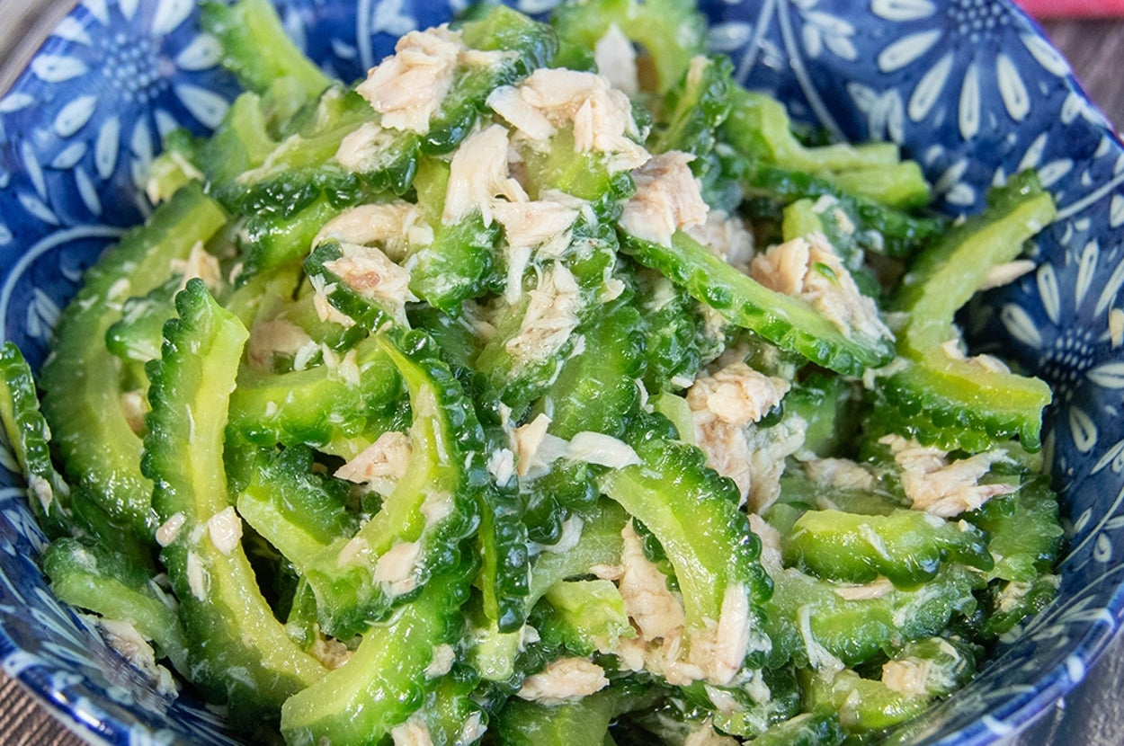 青い皿に盛られたゴーヤとツナの和え物。