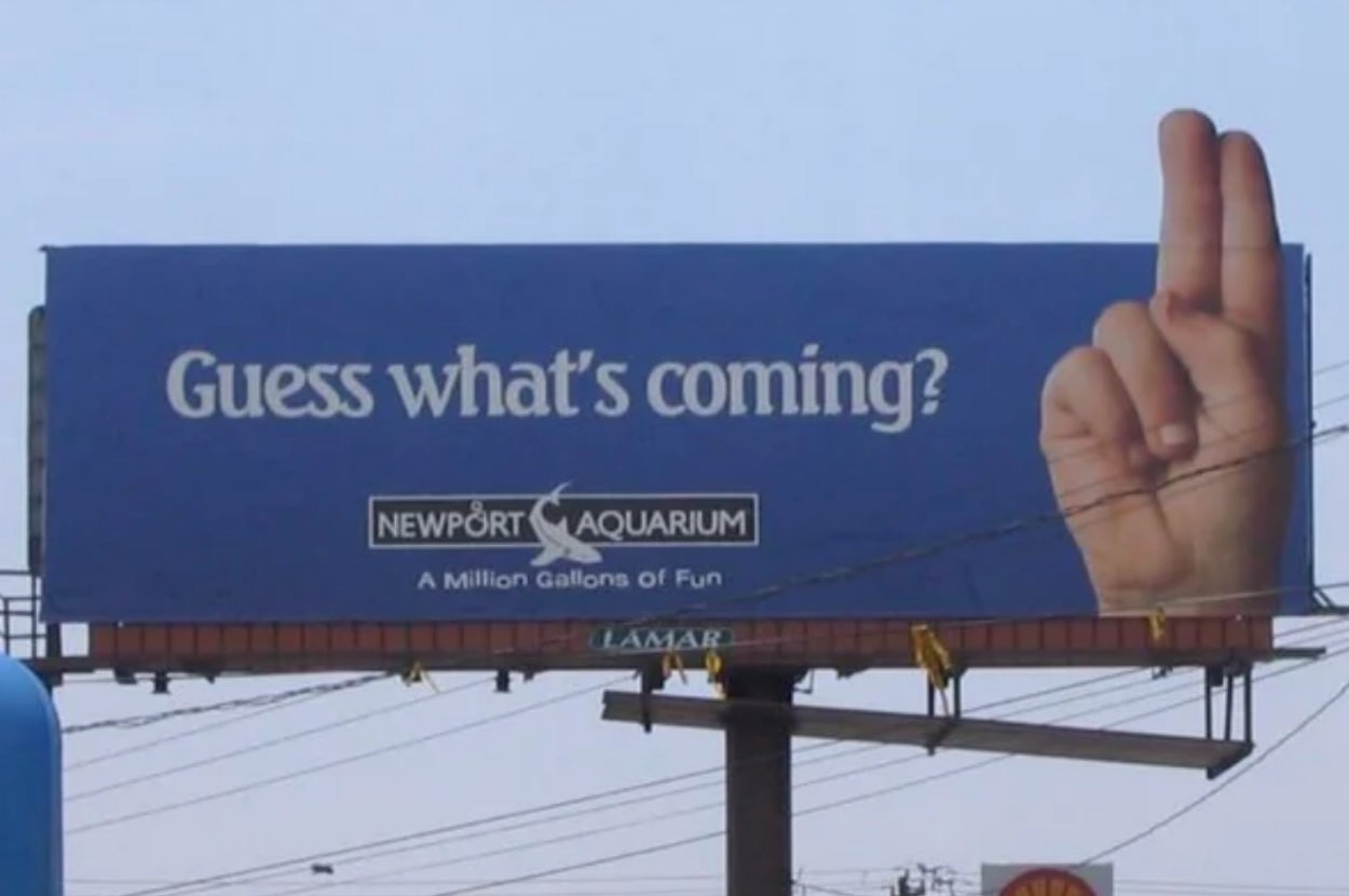 Billboard for Aquarium reads "Guess what's coming?" and shows a hand holding 2 fingers up