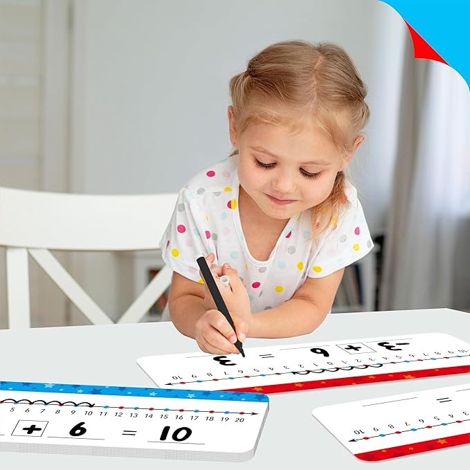 Child using addition learning cards at a table, writing with a pen