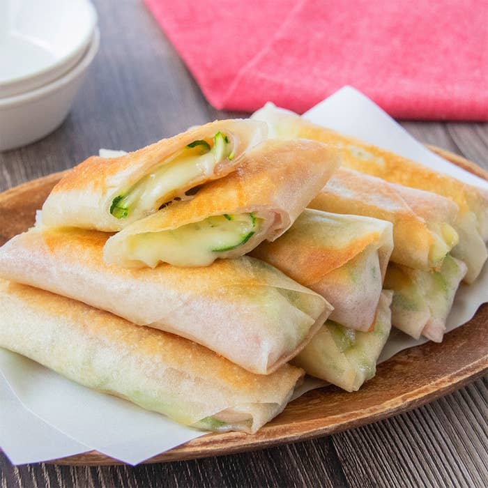 皿に盛られたズッキーニとベーコンの春巻き。揚げ焼きで作られている。