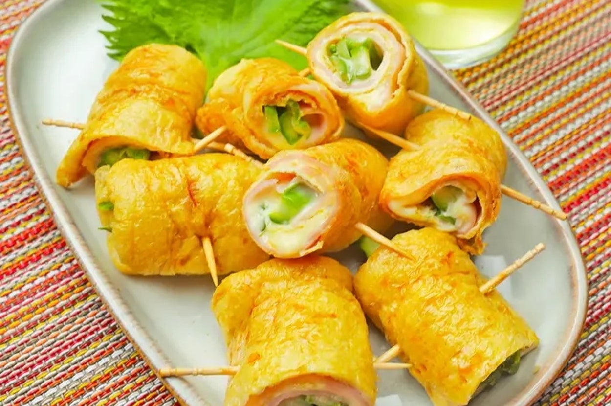 皿に盛られた油揚げ料理。大葉と飲み物が添えられている。