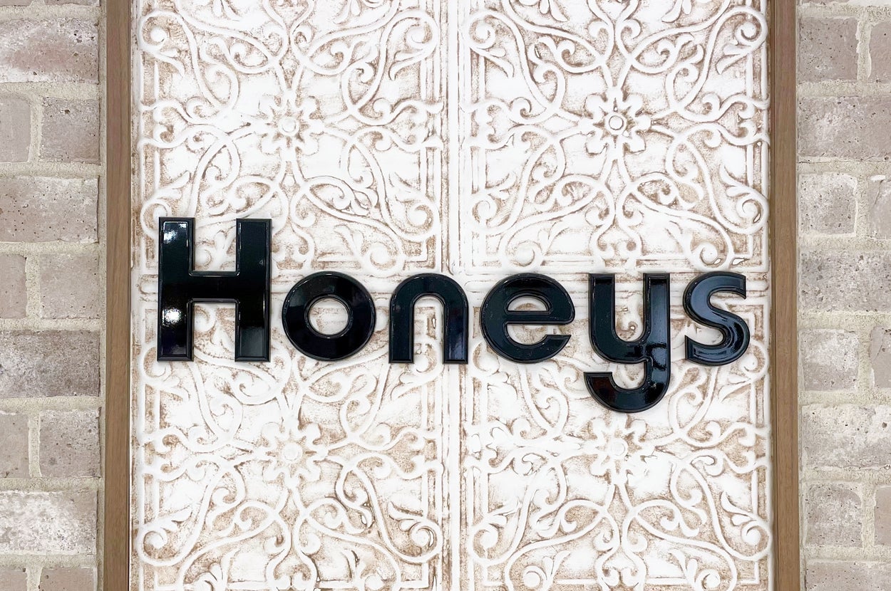 レンガの壁に飾られた「Honeys」という立体的な文字ロゴが中央に配置されている。