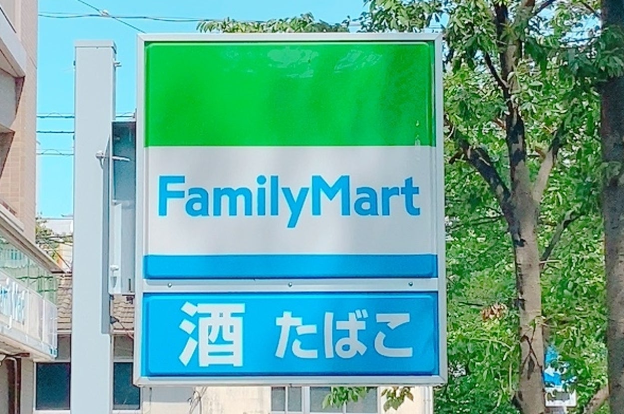 FamilyMartの看板が見える街角の風景。その下に「酒」「たばこ」と書かれたサインがあります。