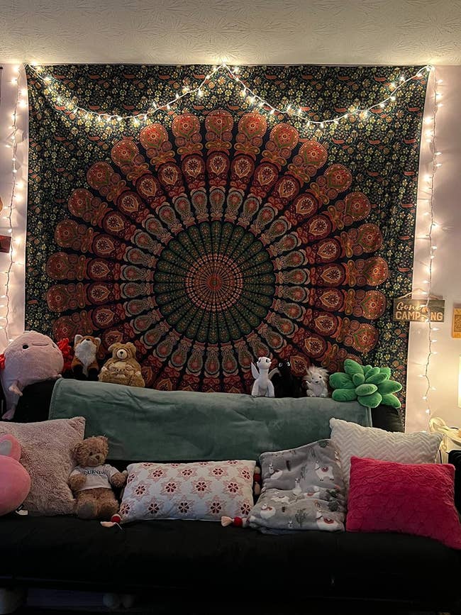 Cozy surviving  country   with a mandala tapestry, drawstring  lights, and plush toys connected  a sofa  with patterned pillows, creating a relaxed atmosphere